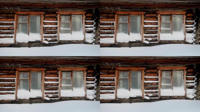 被雪覆盖的木屋。冬季景观中的俄罗斯村庄。西伯利亚。4K