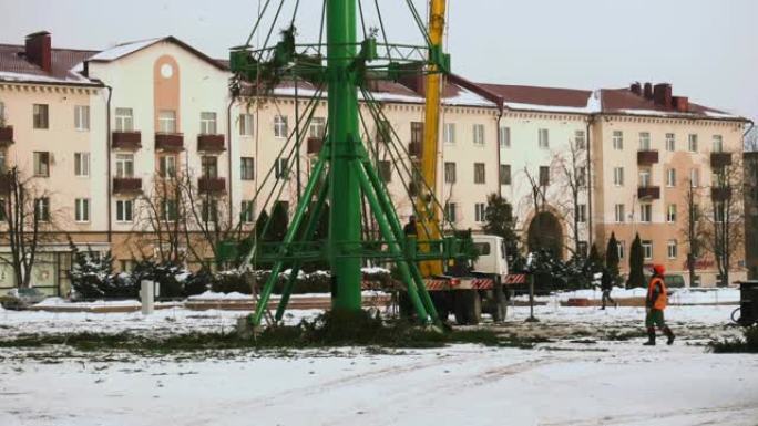 新年假期和庆祝活动结束后，工人们在城市的主要中心广场拆卸了圣诞树结构。第6部分。冬季的高空作业平台。