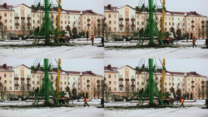新年假期和庆祝活动结束后，工人们在城市的主要中心广场拆卸了圣诞树结构。第6部分。冬季的高空作业平台。