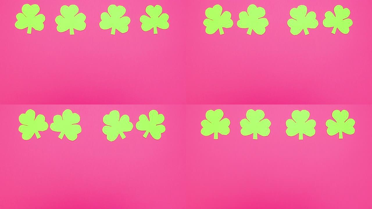 四个绿色三叶草在粉红色背景上移动-停止运动