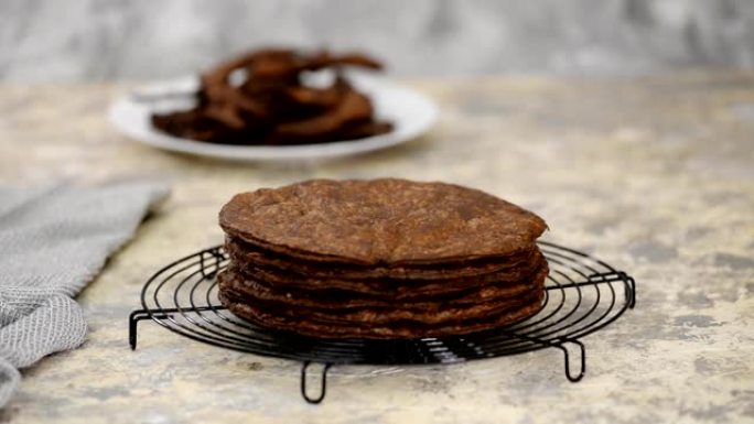 新鲜出炉的圆形酥皮糕点层，用于自制传统巧克力拿破仑蛋糕在冷却架上。