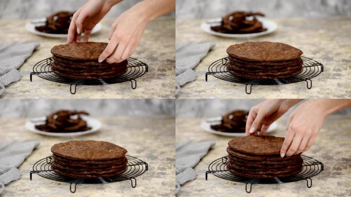 新鲜出炉的圆形酥皮糕点层，用于自制传统巧克力拿破仑蛋糕在冷却架上。