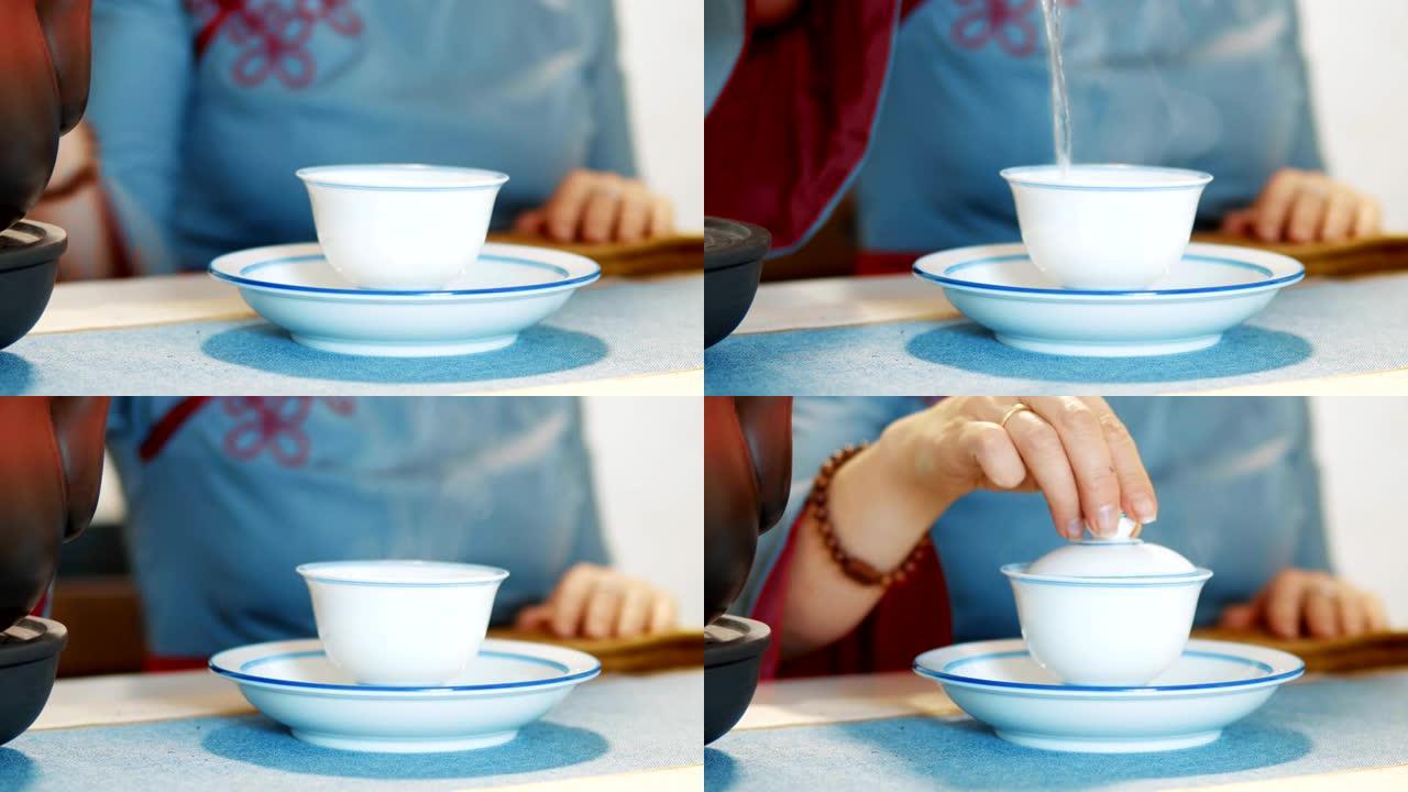 一杯茶里的烟。一个女人在茶道上把开水倒入杯子里。特写