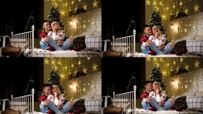 一对相爱的夫妇坐在床上，背景是一棵装饰好的圣诞树。