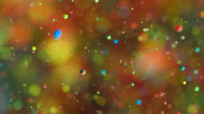 粒子在空间中的抽象混沌运动。慢动作明亮的颜色气泡油画宇宙移动多色特写。丙烯酸涂料。神奇的催眠表面。大