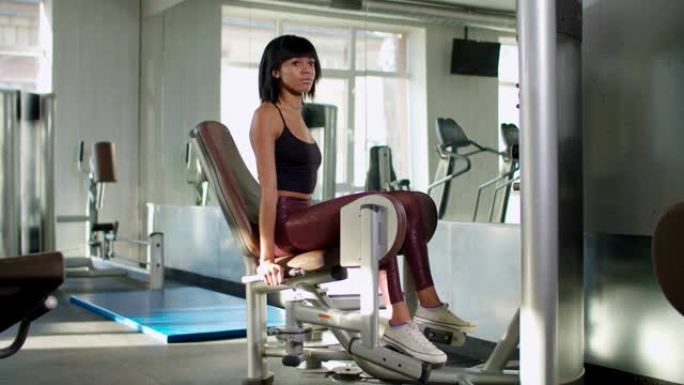 女性在大腿内侧机器上进行体重锻炼