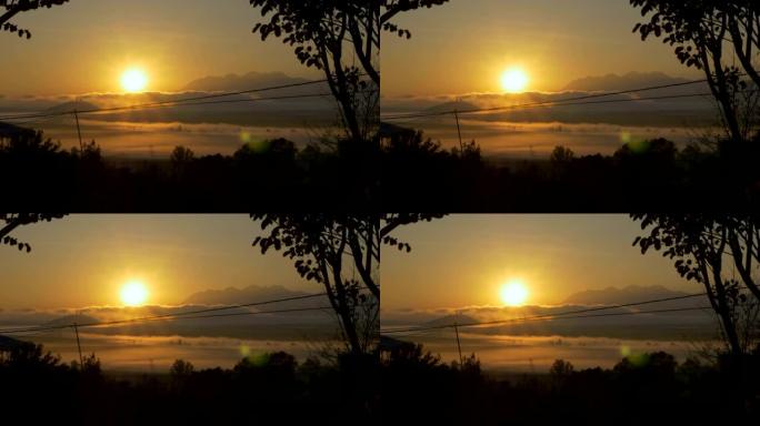 太阳落山在云层和电力线的山湖上