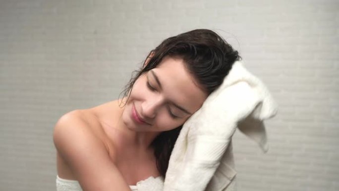 女人用毛巾擦干湿头发。