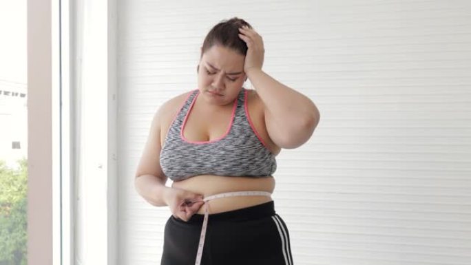 年轻女性在用卷尺或线带测量腰部后会感到体重增加。加大码肥胖成熟女性和超重年轻女性概念