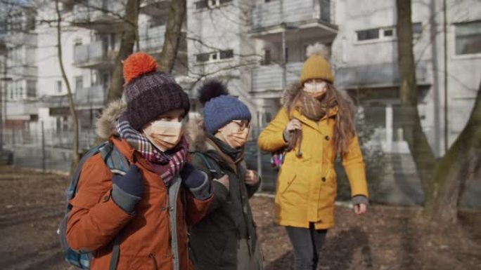 三个孩子戴着防病毒面具上学