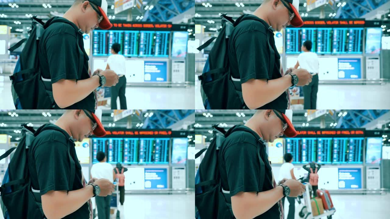 背包客男子在机场休息室使用手机的场景，男子在机场登机柜台前检查时间和航班