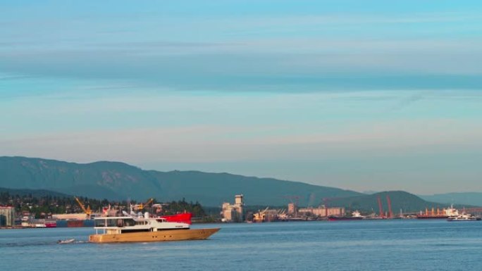 机动游艇在北温哥华工业区和大型商船前穿越温哥华港。