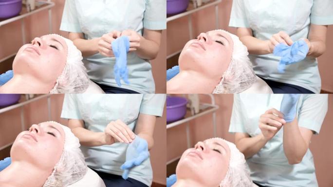 专业女性美容师在进行客户面部美容护肤程序之前，先戴上蓝色橡胶清洁无菌手套。美容专业的概念