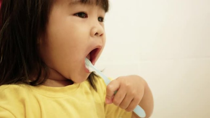 快乐的小女孩刷牙，在浴室用水清洁口腔。口腔卫生概念。