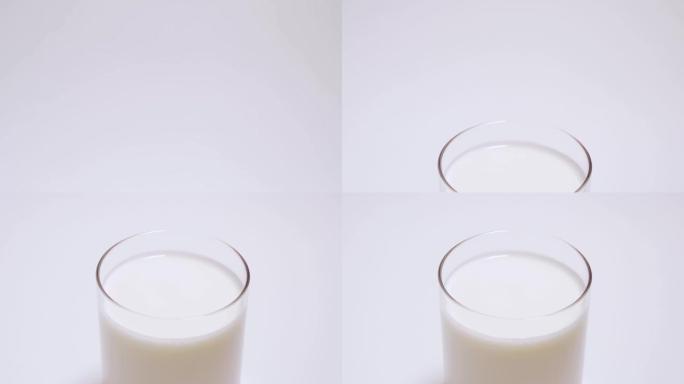 一杯椰奶酸奶慢慢出现在框架中。隔离在白色背景4k
