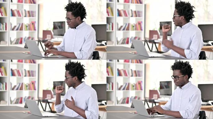 生病咳嗽的非洲男子在笔记本电脑上工作