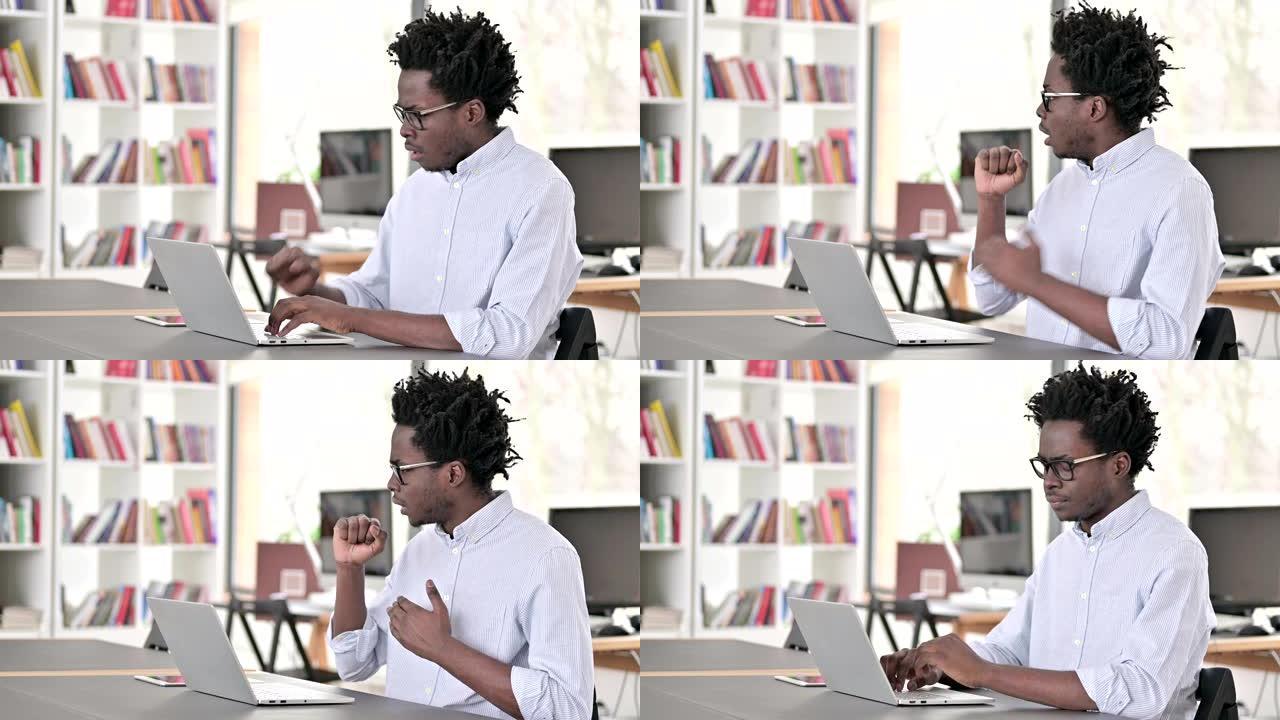 生病咳嗽的非洲男子在笔记本电脑上工作