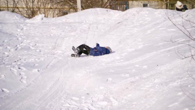 快乐的男孩快乐地躺在雪地上。
