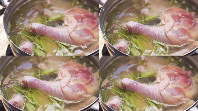鸡大腿在大锅里煮沸。做鸡汤。温暖的菜单