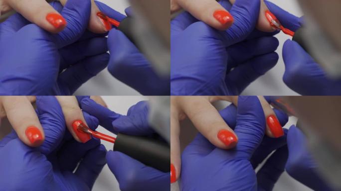 专业美容师美甲大师抛光指甲特写。正在修指甲的女人。用红色清漆覆盖指甲。美容院的指甲修指甲过程