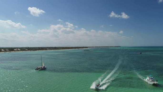 多米尼加共和国蓬塔卡纳的热带度假。海滩度假村的鸟瞰图。滑翔伞。游艇。海中的双体船和快艇。多米尼加共和