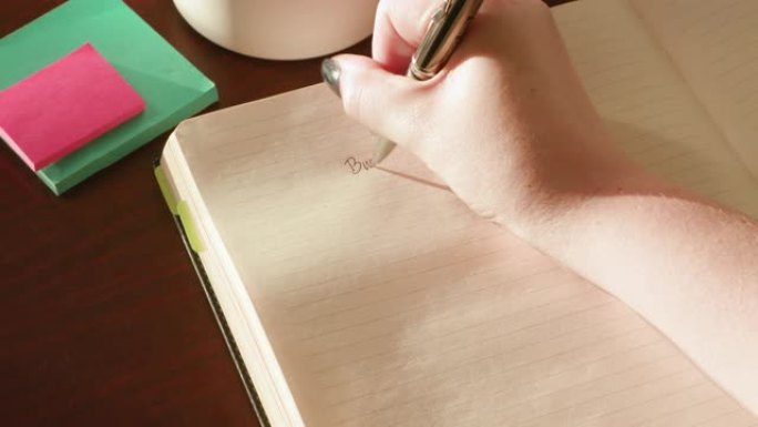 女人在木桌上的日记中写遗愿清单