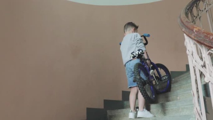 一个男孩把自行车抬上楼梯