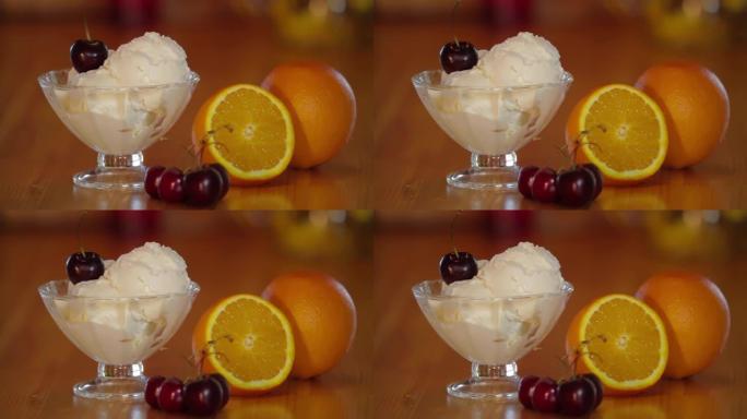 冰淇淋勺上的樱桃。冰激凌，玻璃碗里有樱桃，木桌上有橙色。冰淇淋冰淇淋的制备。甜冷甜点。