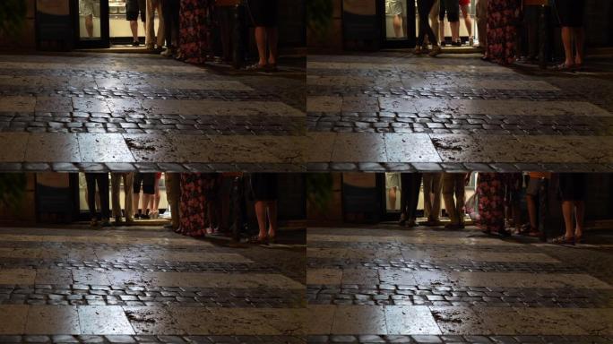 晚上照亮了鹅卵石路，一群人在意大利冰淇淋店门前排队。意大利文化、旅游和传统美食