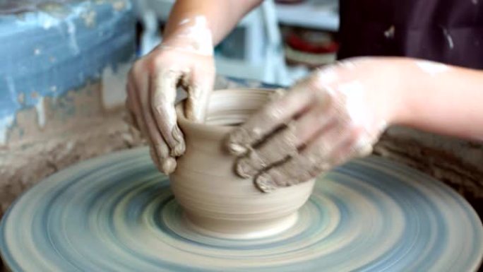 陶艺班作坊。陶工轮子上的粘土造型。波特向孩子们传授手艺