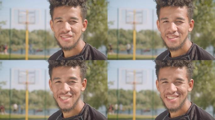 年轻英俊的非洲裔美国男子篮球运动员在户外快乐地看着相机的特写肖像