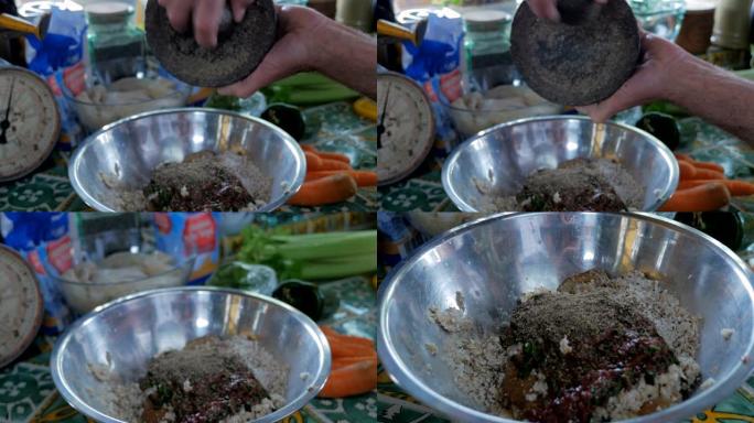 厨师的特写，将研钵和杵中的胡椒粉加入到matzo mix中