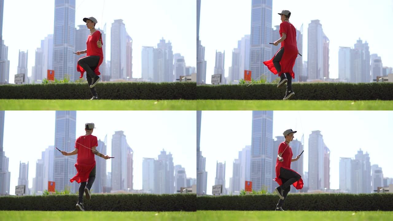 迪拜城市景观背景下的绿色草地上跳绳的年轻女孩