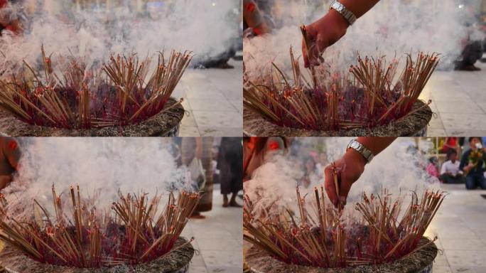 传统的火焰点燃香烛祈祷在佛教寺庙火焰烛光燃烧温暖的光与烟香烛。