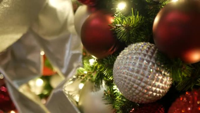节日装饰的户外圣诞树的特写镜头，模糊的闪闪发光的童话背景上有鲜红色的球。散焦花环灯，波克效应。圣诞快