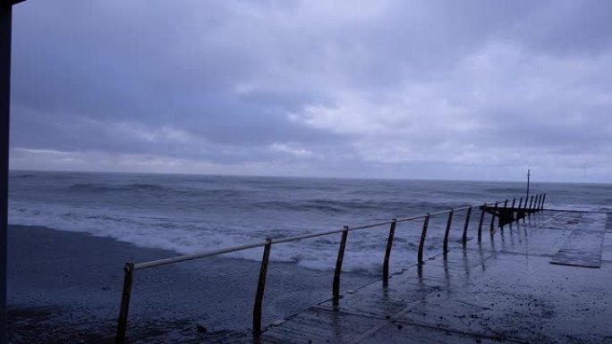 大浪冲向海岸线。喷涂泡沫。