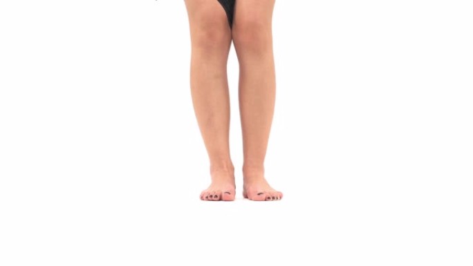 年轻漂亮的白人女人穿着黑色蕾丝内裤。特写的苗条女性的腿。孤立，在白色背景上