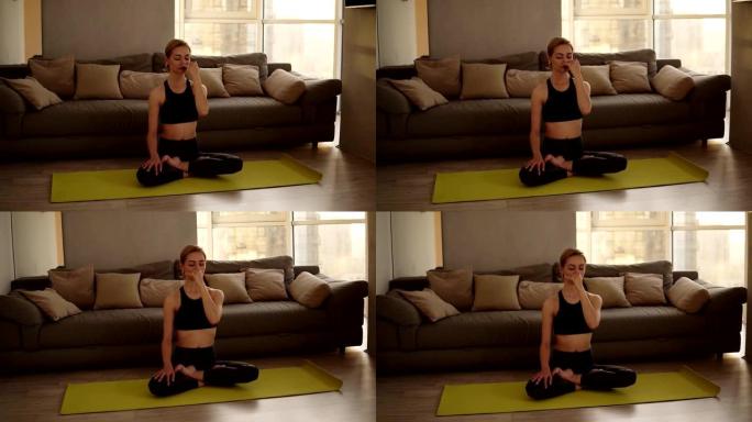 高加索人，金发女子练习瑜伽，坐在莲花姿势，在室内进行交替鼻孔呼吸技术。做纳迪·肖德纳调息治疗运动。背