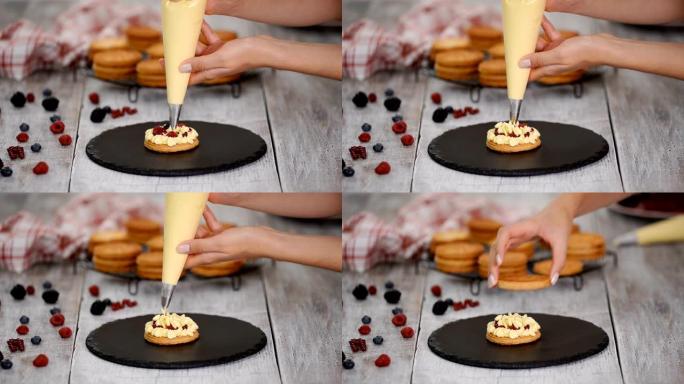 糕点厨师用奶油冻和浆果制作法国Mille Feuille。法式甜点油酥和奶油。