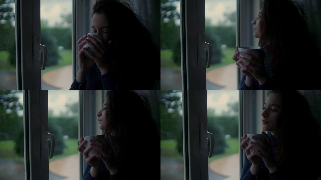 窗户附近喝咖啡的年轻女子
