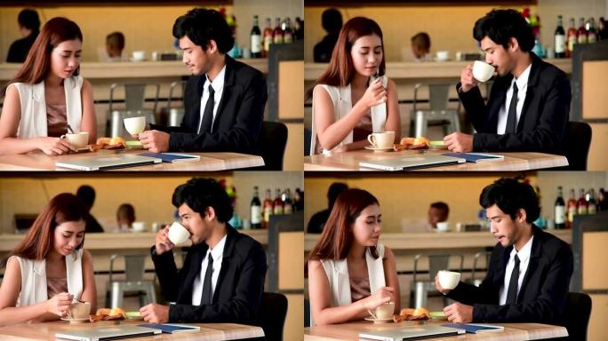 年轻夫妇在咖啡馆咖啡店聊天快乐约会情侣交流积极的关系，同时在咖啡馆喝咖啡放松，健谈。情人节概念。