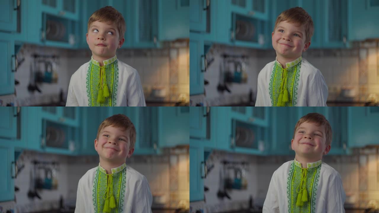 穿着刺绣民族服装的金发男孩在蓝色厨房里微笑着展示着自己的情感。穿着白色针织衬衫的孩子，慢动作中有民族