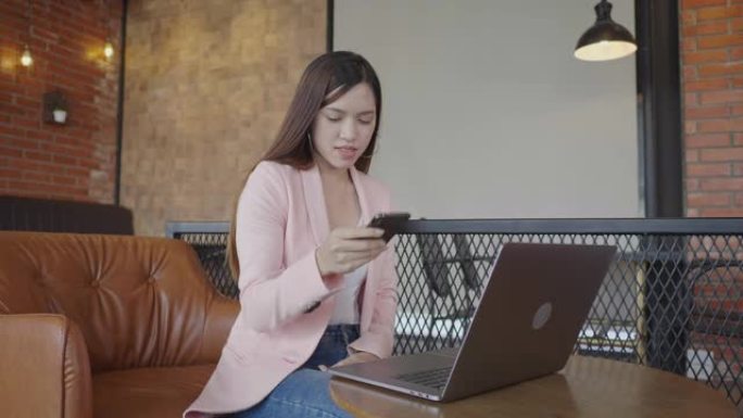 Beautiful Asian female freelancer using her smart 