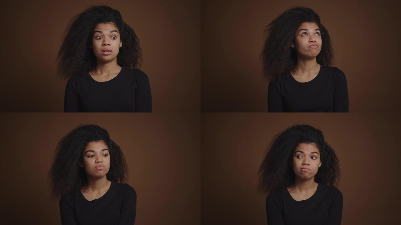 非裔美国女孩对相机的棕色背景表示沮丧