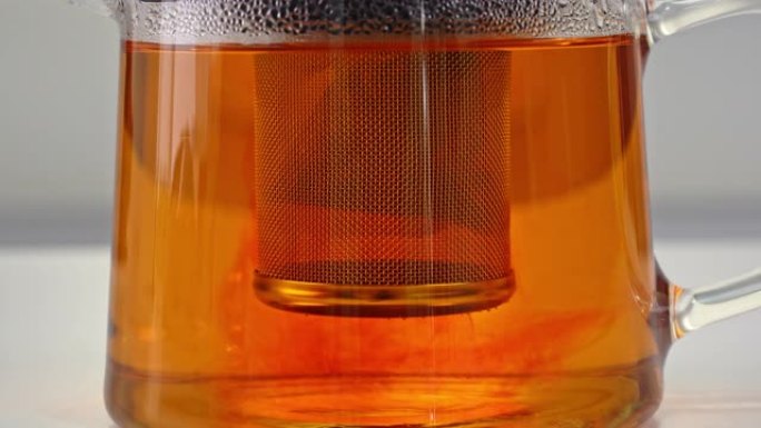 用袋泡茶冲泡并将红茶叶浸泡在玻璃透明茶壶中，用煮沸的热水，延时拍摄，特写镜头，4K。
