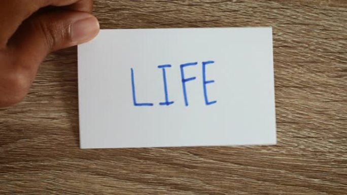 手工翻转工作到生活文字的纸质卡片在木背景上，工作动机生活平衡概念