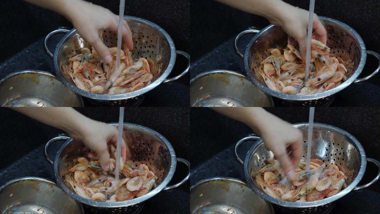 厨师煮海鲜。女人在厨房里准备虾。厨师在水槽里洗虾。家庭烹饪。洗虾的过程