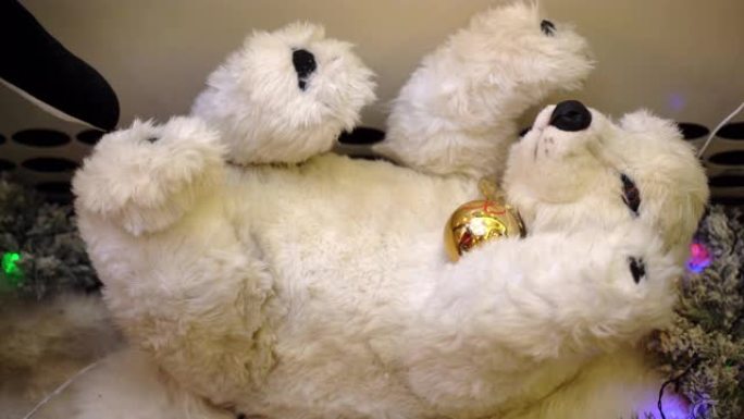 可爱的蓬松白色泰迪熊移动玩具在木制雪橇上，带有圣诞装饰品，音乐动画玩具在购物中心表演。泰迪熊和快乐的