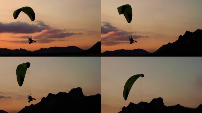 在泰国华富里的Khao Jeen Lae山上日落时，滑翔伞在空中飞行的慢动作