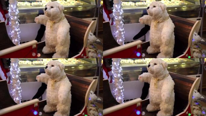 美丽蓬松的白色泰迪熊在木制雪橇上，当地酒吧有圣诞装饰。令人惊叹的儿童机械移动玩具，泰迪熊展示圣诞节假
